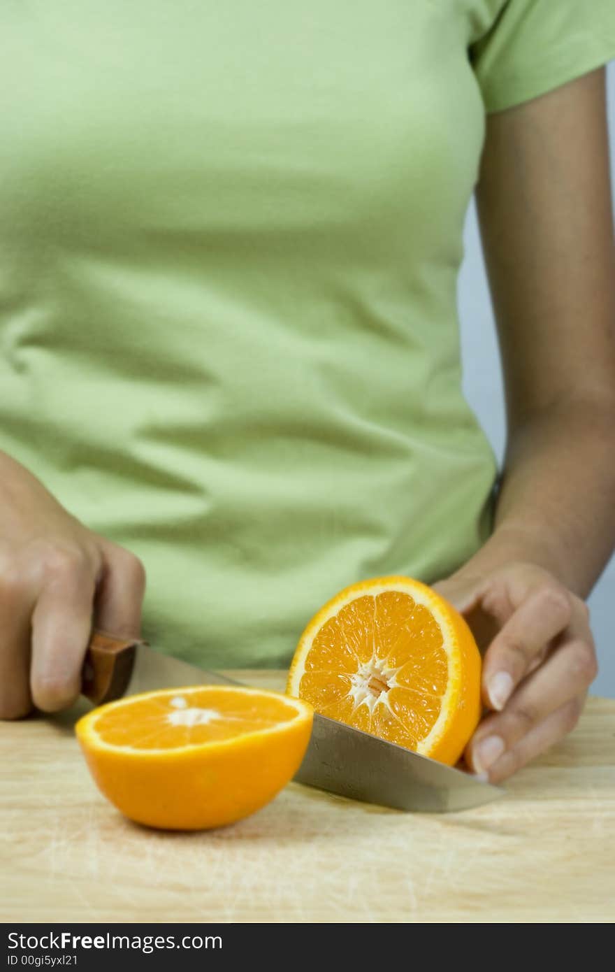 Girl cutting orange with knife