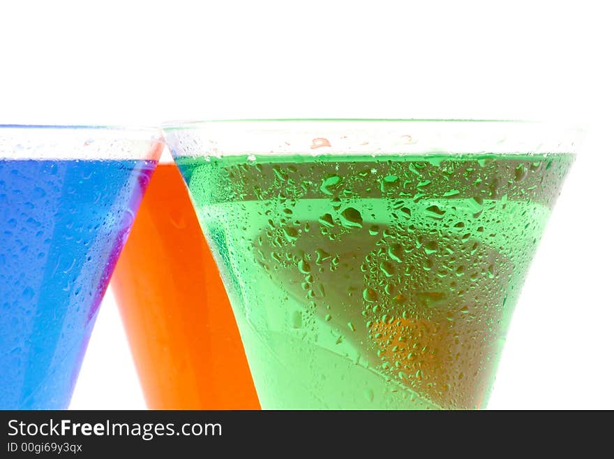 Red green and blue liquids in a glasses on a white background. Red green and blue liquids in a glasses on a white background