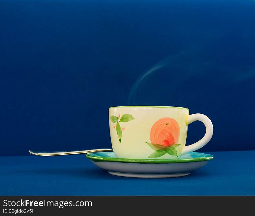 Steaming coffee cup on blue