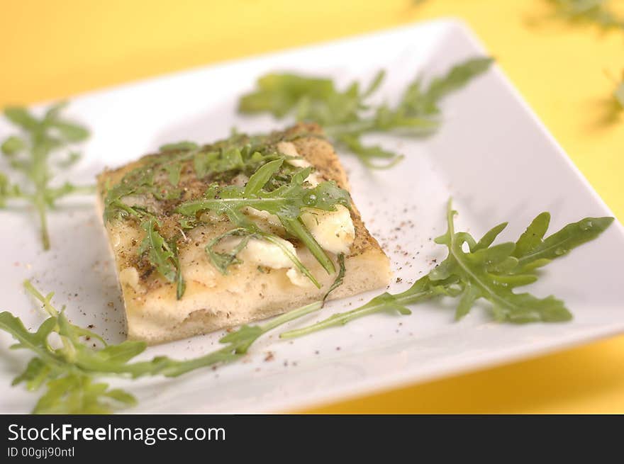 proud pizza with herbs and cheese on the yellow background