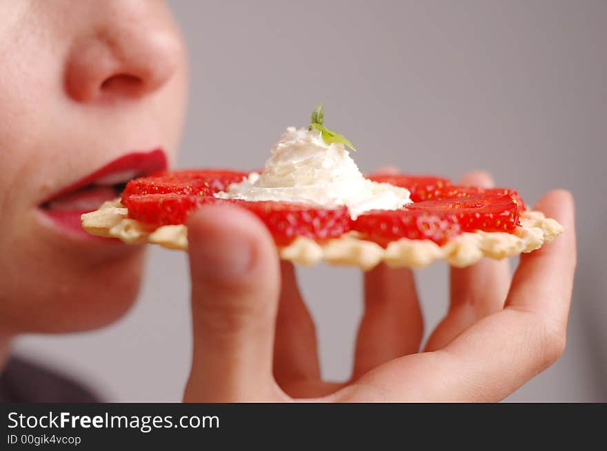 the woman eats strawberries on the blue background. the woman eats strawberries on the blue background