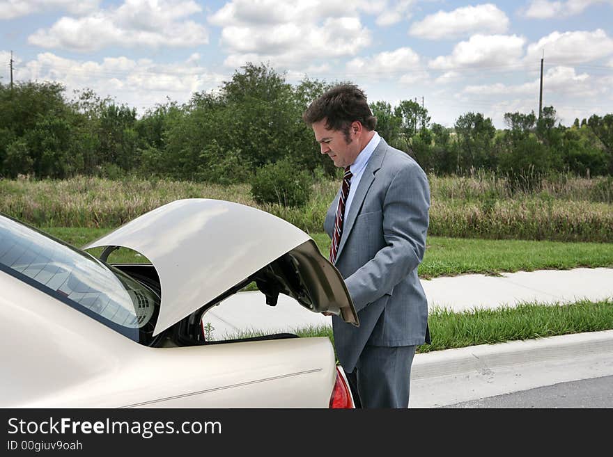 A businessman on a road trip, opening his trunk. A businessman on a road trip, opening his trunk.