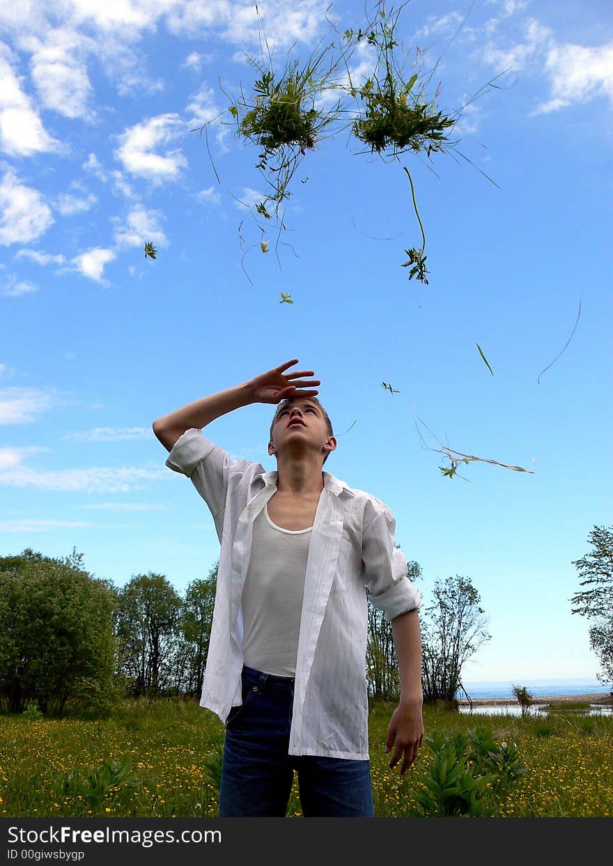 The boy throws a grass on a background of Baikal. The boy throws a grass on a background of Baikal