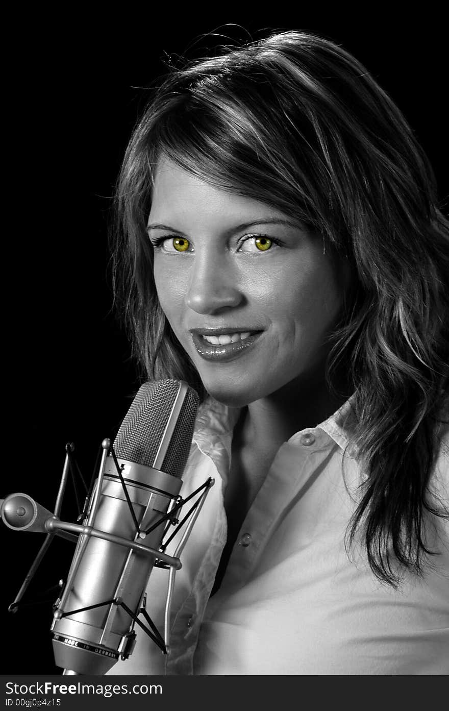 Beautiful woman with vintage microphone over a black background.