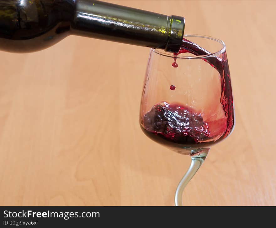 The red wine flowing from a bottle in a glass