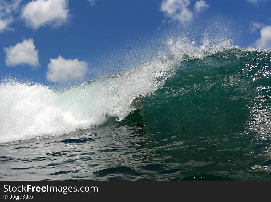 A shortboard surfer deep in the barrel in hawaii. A shortboard surfer deep in the barrel in hawaii