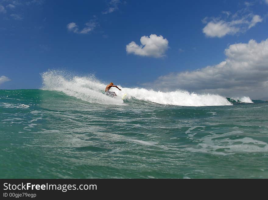 A shortboard surfer surfing on a beautiful wave in hawaii. A shortboard surfer surfing on a beautiful wave in hawaii