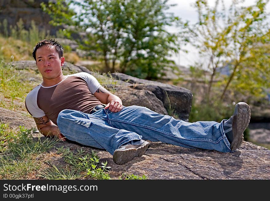 A young asain man relaxing at the park. A young asain man relaxing at the park