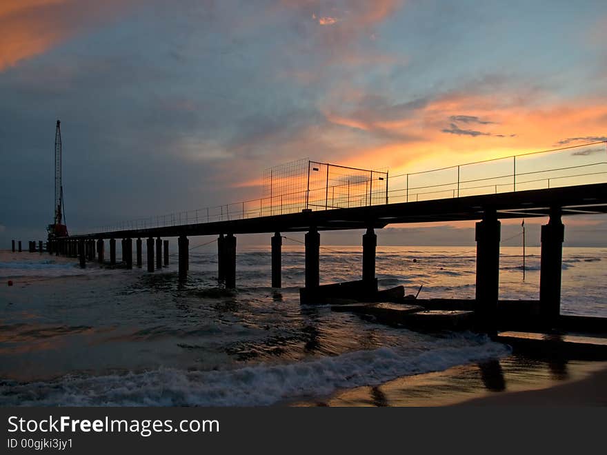 Pier is built in the italian coastline. Dramatic sunset. Pier is built in the italian coastline. Dramatic sunset.