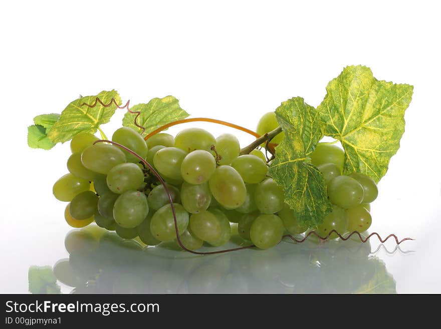 Green grape cluster with leaves on a white background