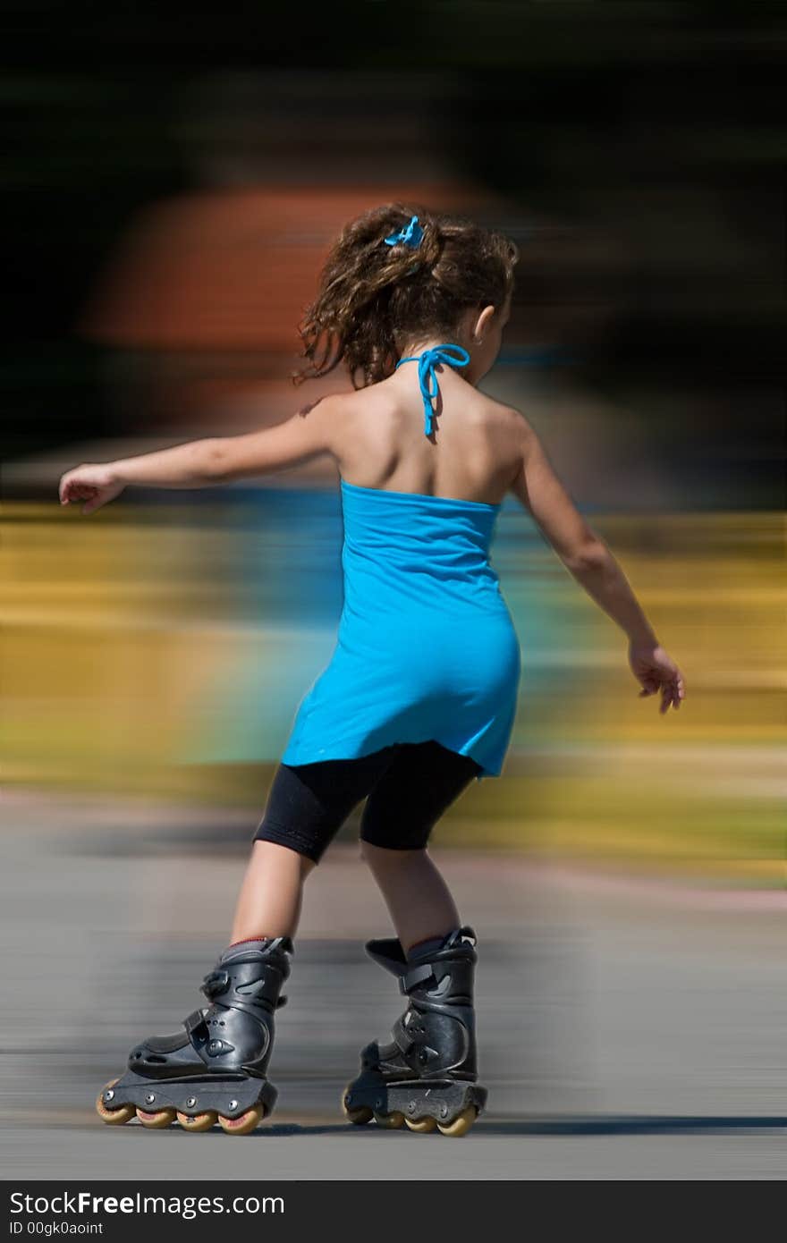 Young girl in blue dress skating in speed in the park. Young girl in blue dress skating in speed in the park