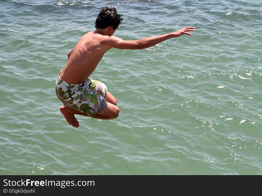 Boy jumping into te ocean. Boy jumping into te ocean