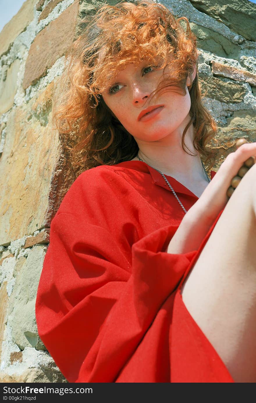 Girl in red on masonry background