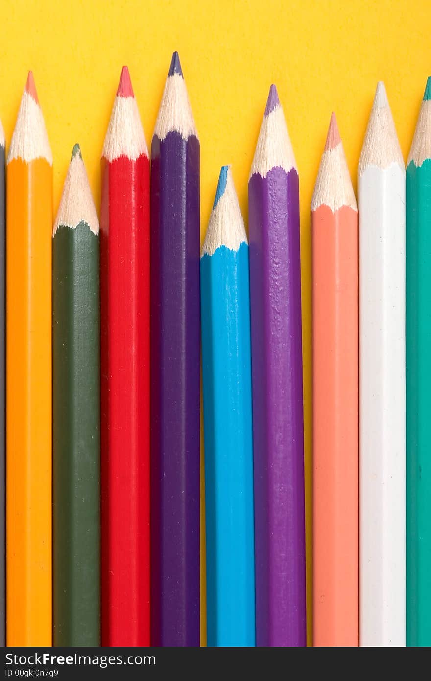 Thick colored pencils against a yellow background color