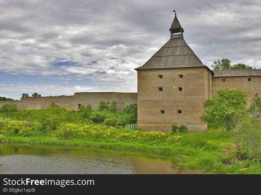 Medieval castle and green trees under sky with clouds. Medieval castle and green trees under sky with clouds