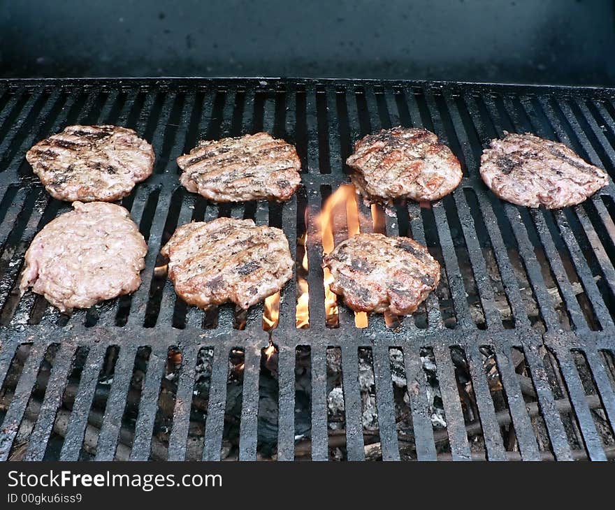 Photo of a burgers being cooked on a smoker grill. Photo of a burgers being cooked on a smoker grill