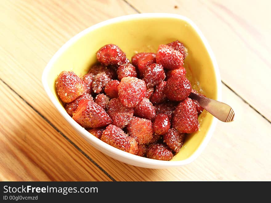 Sugared strawberries in a yellow bowl