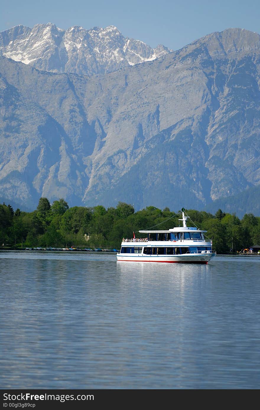 Motor ship in Alps lake with mountains background. Motor ship in Alps lake with mountains background