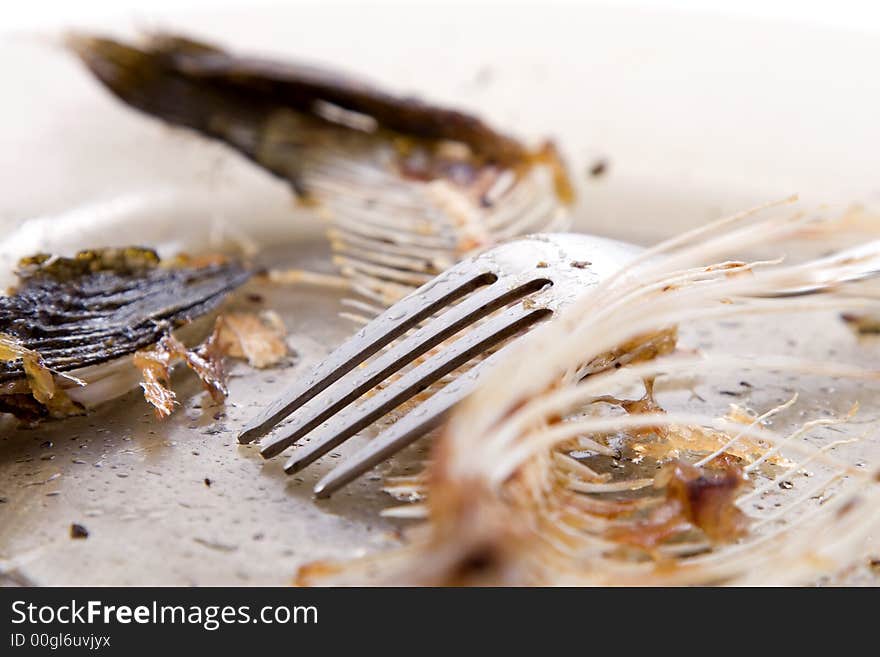 Fishbones on  plate, near forks