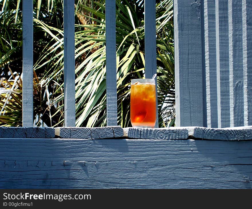 A delicious glass of iced tea on the deck of a tropical paradise. A delicious glass of iced tea on the deck of a tropical paradise.