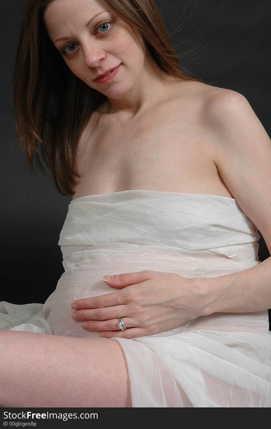 A powerful image of an expecting mother wrapped in white to show off her pregnant belly. A powerful image of an expecting mother wrapped in white to show off her pregnant belly.