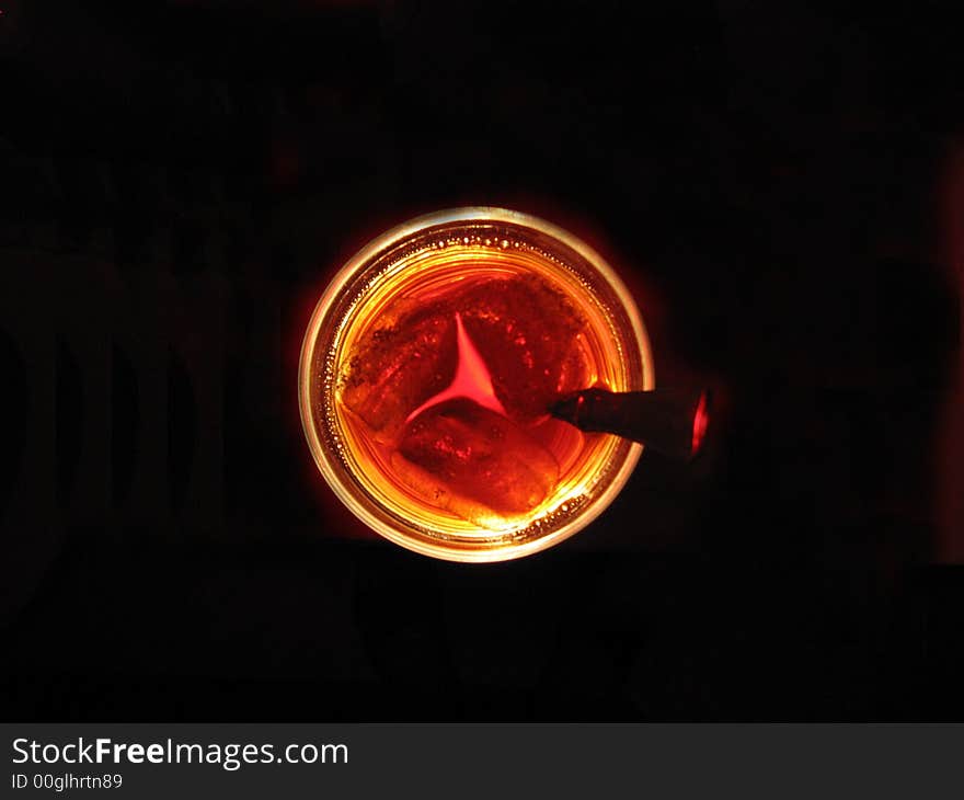 A glass of iced tea eerily glowing in the dark.