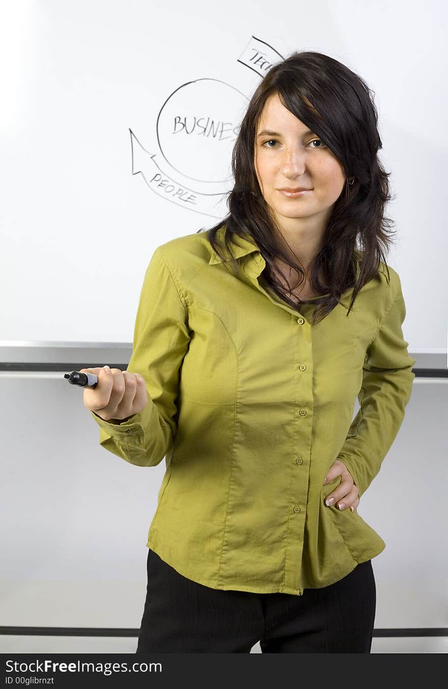 Beauty businesswoman standing in front of blackboard. Giving somebody the marker. Gray background. Beauty businesswoman standing in front of blackboard. Giving somebody the marker. Gray background