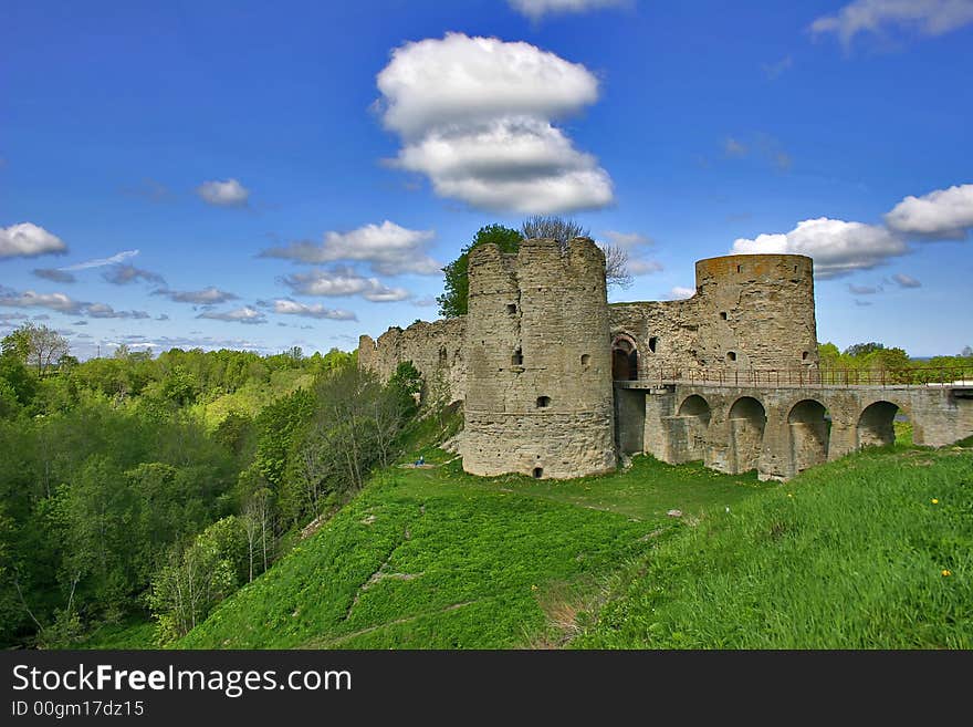 Medieval castle and green trees under blue sky with clouds. Medieval castle and green trees under blue sky with clouds