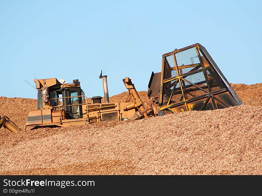 Earth mover buried deep in wood chips