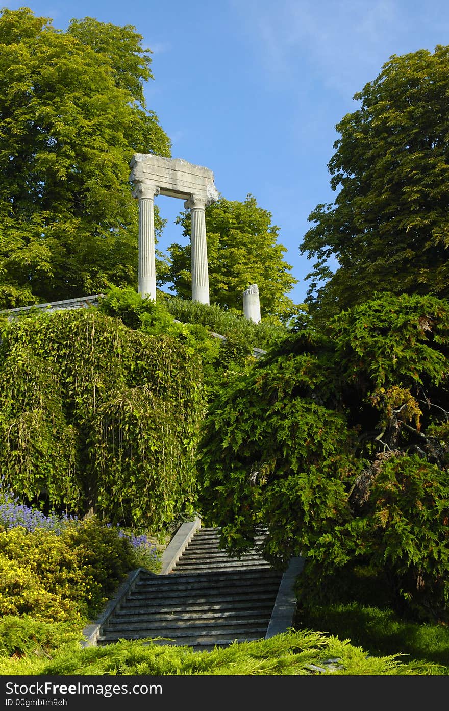 The remains of a Roman building standing isolated and mysterious, in the woods, with steps leading up towards them. Space for text in the sky. The remains of a Roman building standing isolated and mysterious, in the woods, with steps leading up towards them. Space for text in the sky.