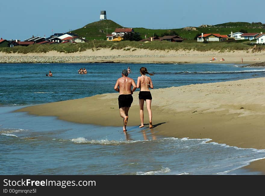 Young Couple Running On Beach