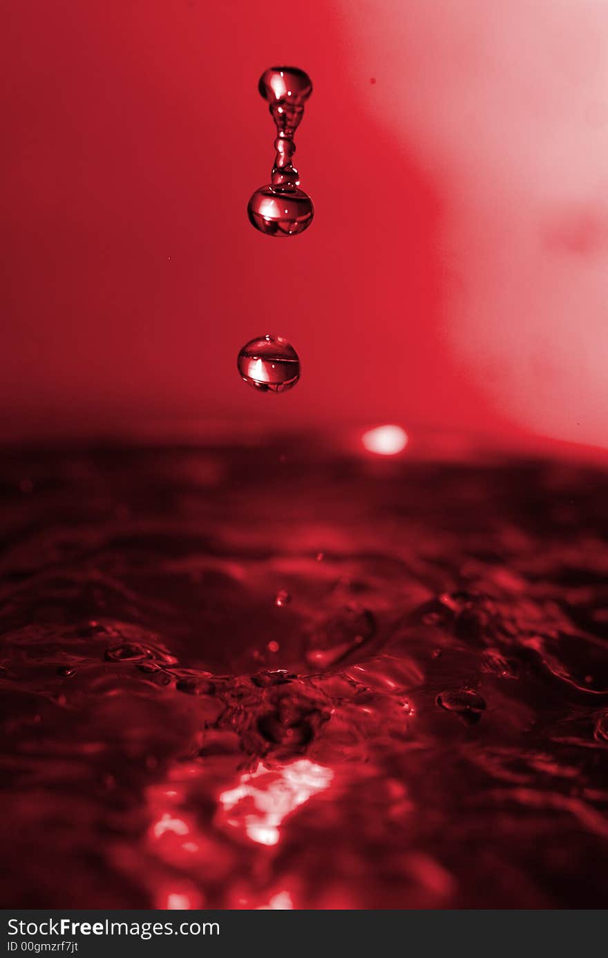 Red water dros dripping on water. Red water dros dripping on water