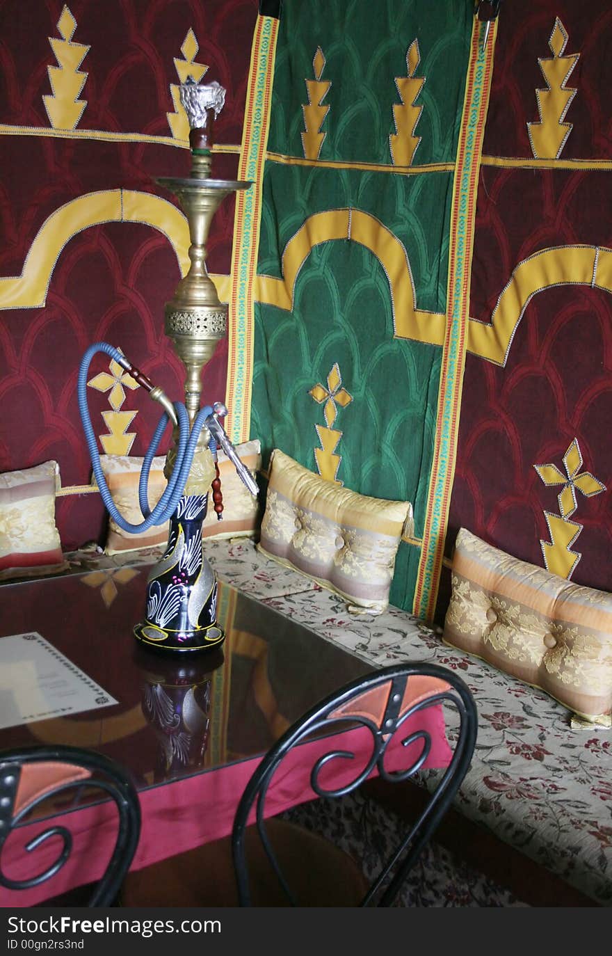 Interior of a Moroccan restaurant with a glass of water on the table - travel and tourism. Interior of a Moroccan restaurant with a glass of water on the table - travel and tourism.