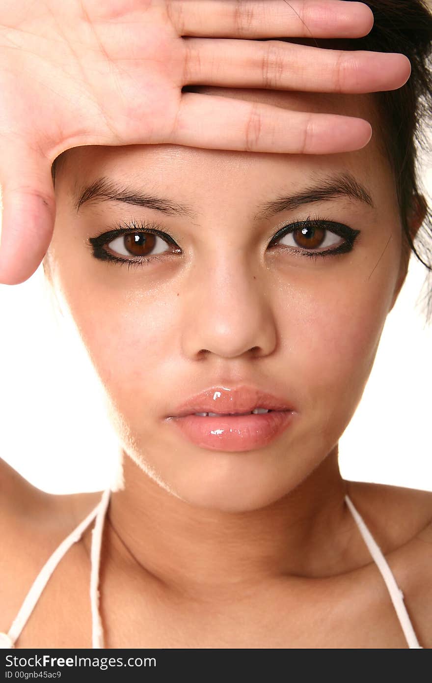 Close up face of beautiful brunette with her hand on her forehead. shot with rim light isolated on white. very sharp eye. Close up face of beautiful brunette with her hand on her forehead. shot with rim light isolated on white. very sharp eye