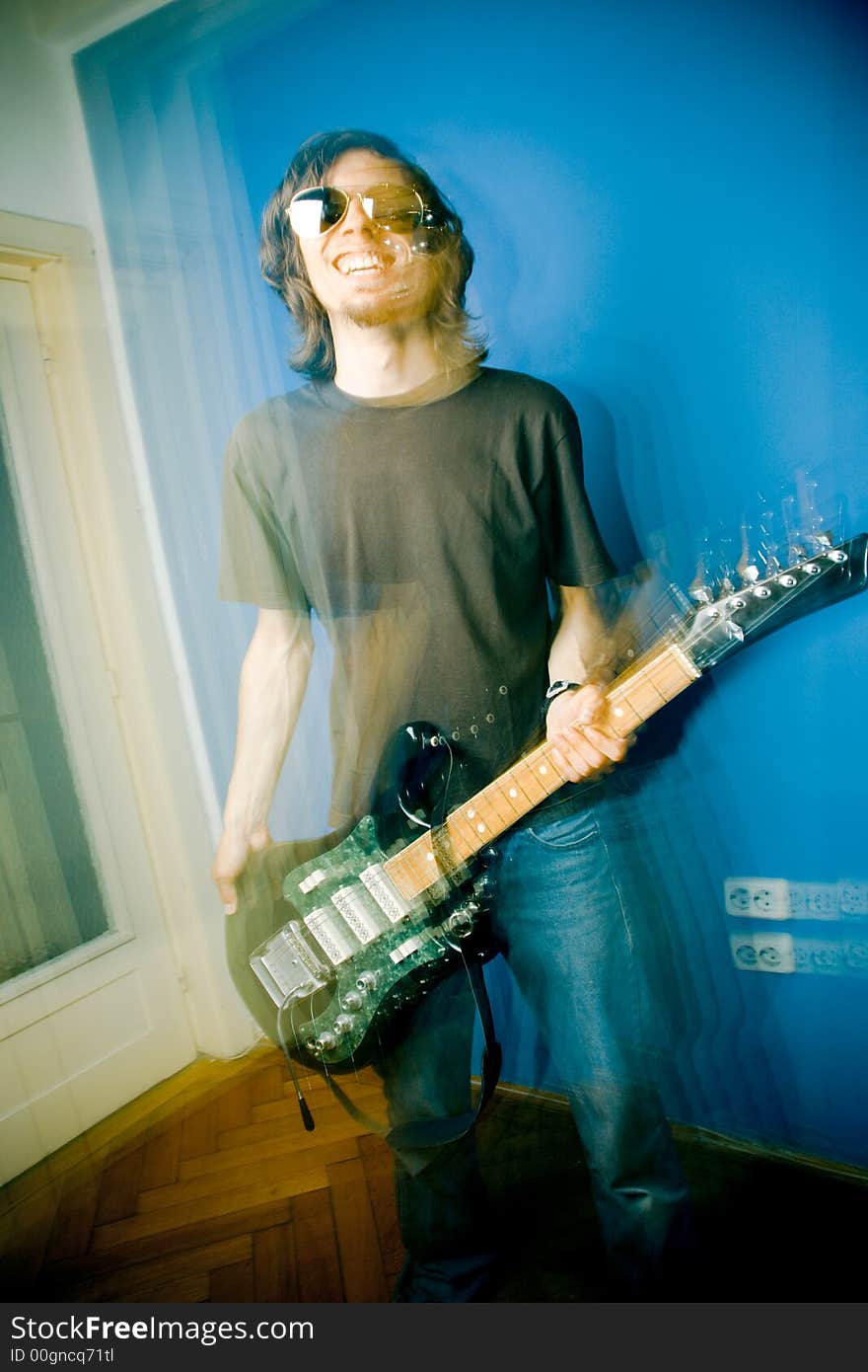 Young man playing electric guitar, zoom and strobe lighting. Young man playing electric guitar, zoom and strobe lighting.