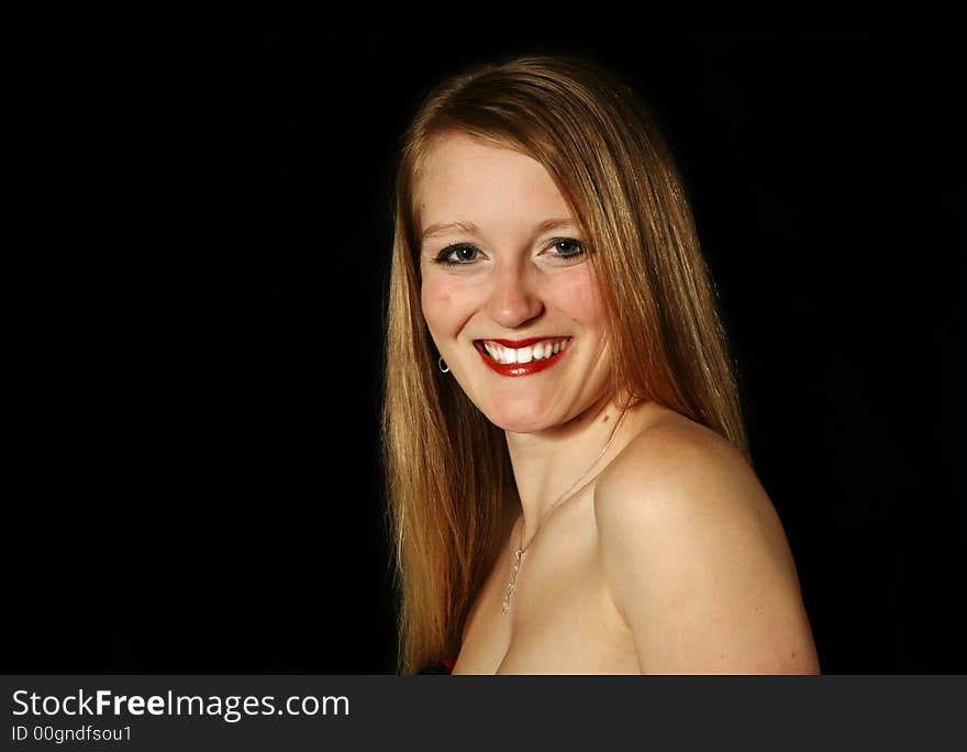 Beautiful blond woman smiling on a black background. Beautiful blond woman smiling on a black background