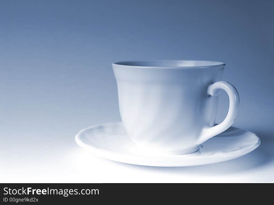 White mug of coffee on a white background, with the admixture of blue tones