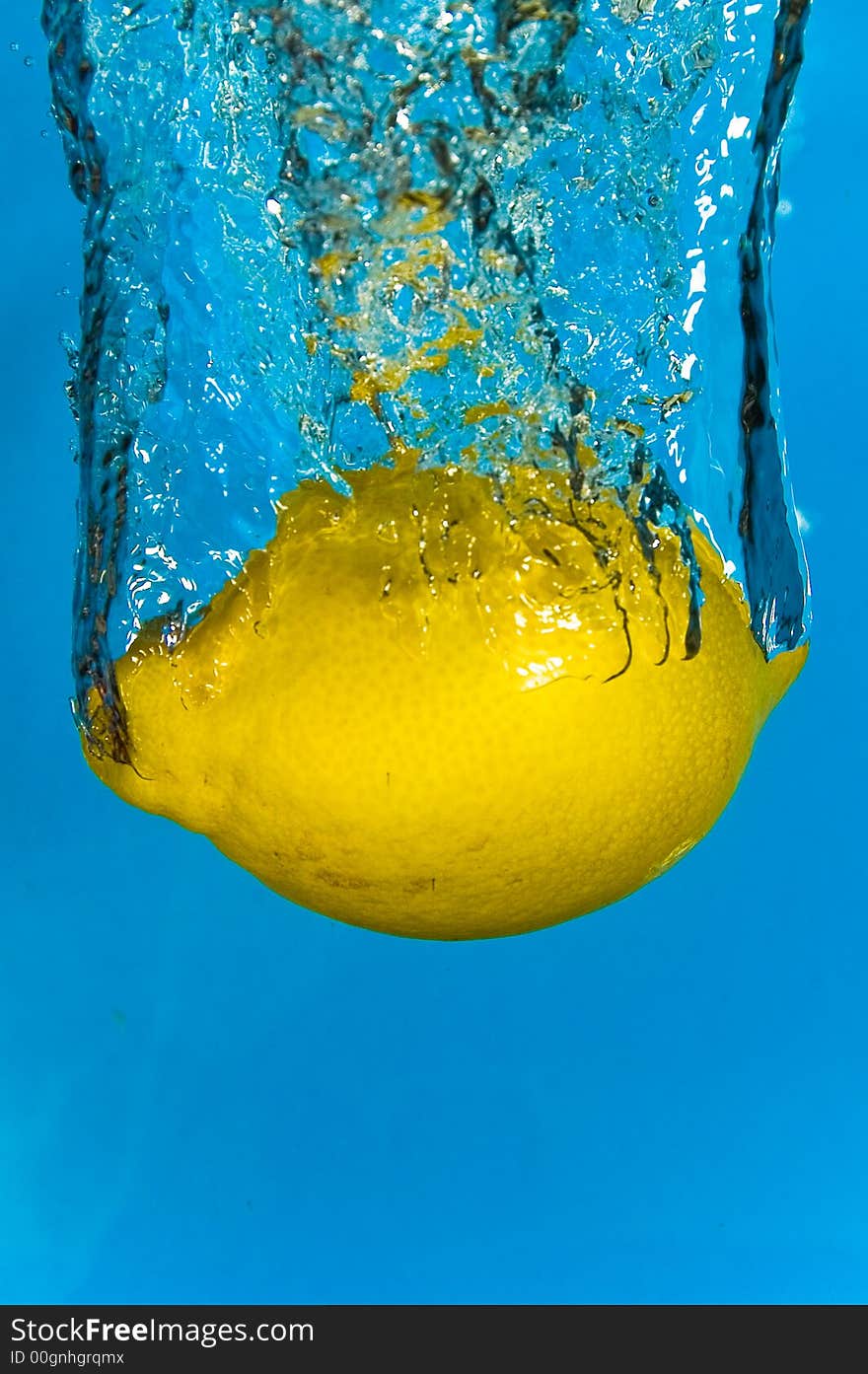 A lemon plunging into refreshing cool water. A lemon plunging into refreshing cool water