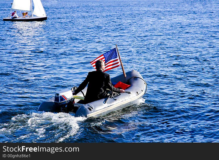 Guy in a three piece suit motoring his yacht tender. Guy in a three piece suit motoring his yacht tender