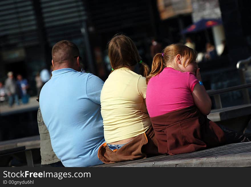 Colourful family sat on a bench