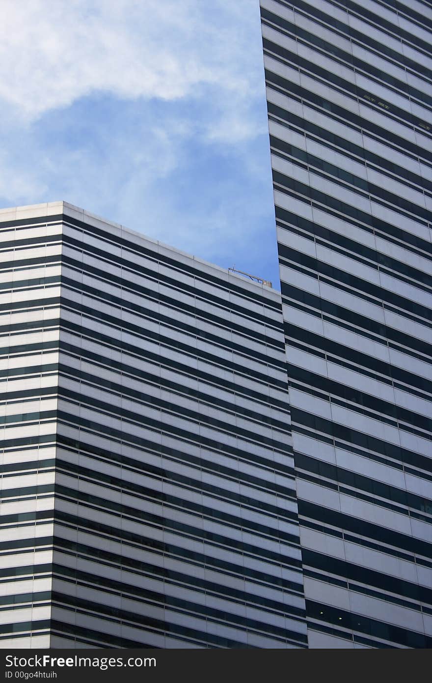 Two Modern buildings with sharp edged ans sky form up a pattern.