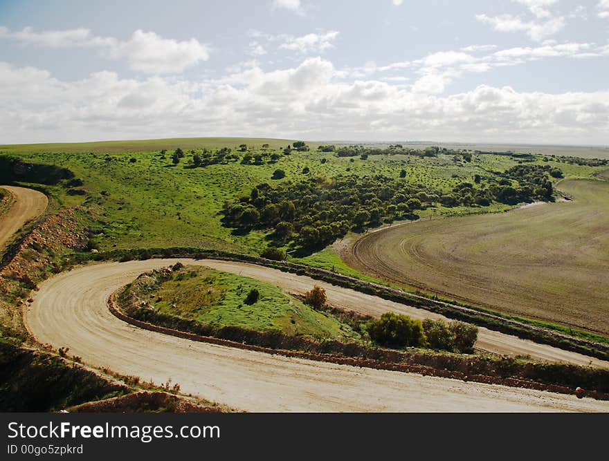 Hilly green landscape with winding country roads and fields. Hilly green landscape with winding country roads and fields.