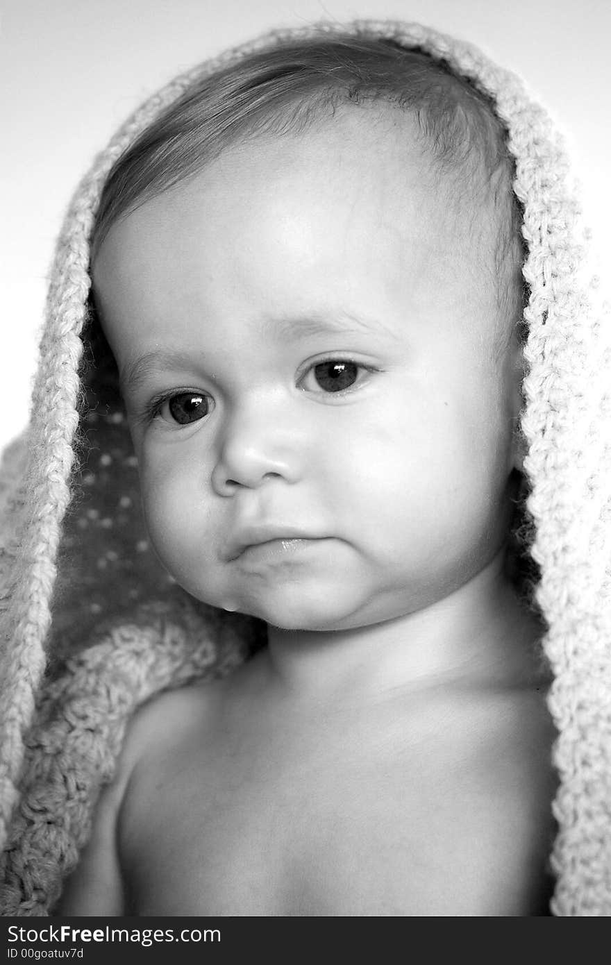 Black and white image of a toddler peeking out from under a blanket. Black and white image of a toddler peeking out from under a blanket