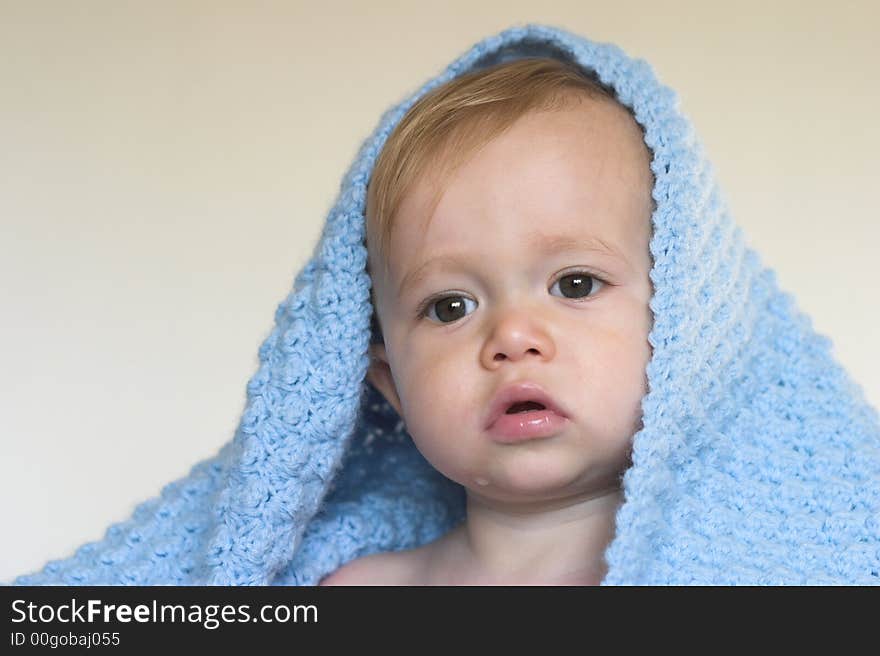 Image of a cute toddler peeking out from under a blanket. Image of a cute toddler peeking out from under a blanket