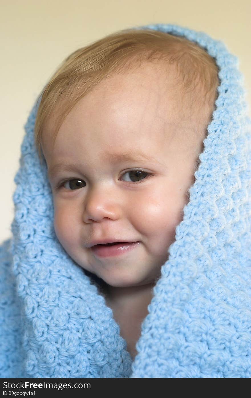 Image of a cute toddler peeking out from under a blanket. Image of a cute toddler peeking out from under a blanket