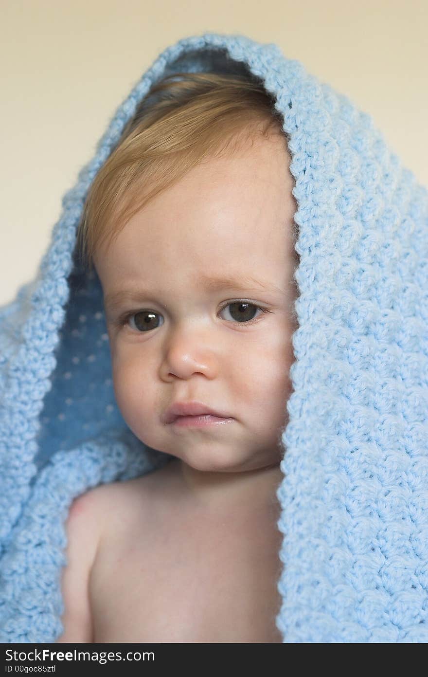 Image of a cute toddler peeking out from under a blanket. Image of a cute toddler peeking out from under a blanket