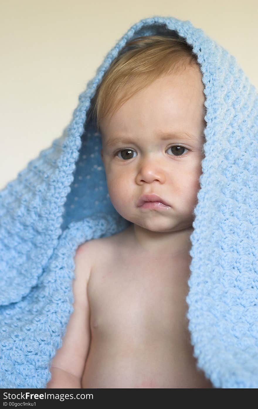 Image of a cute toddler peeking out from under a blanket. Image of a cute toddler peeking out from under a blanket