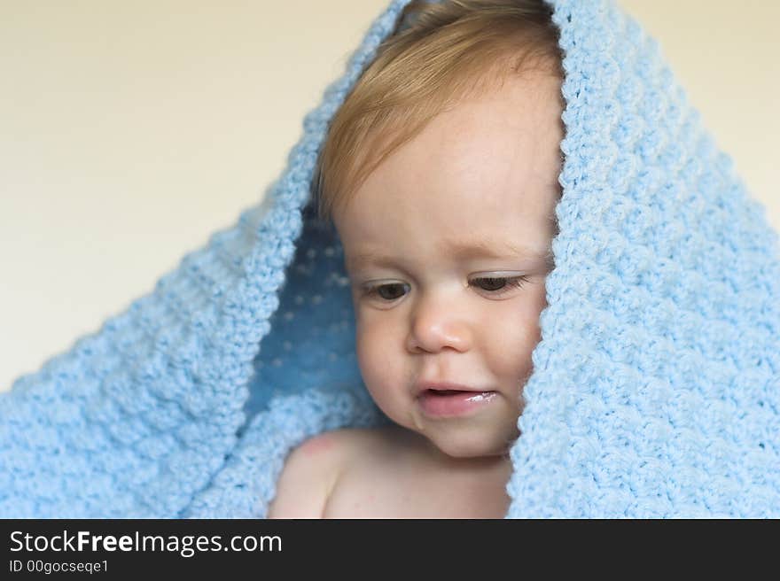 Image of a cute toddler peeking out from under a blanket. Image of a cute toddler peeking out from under a blanket