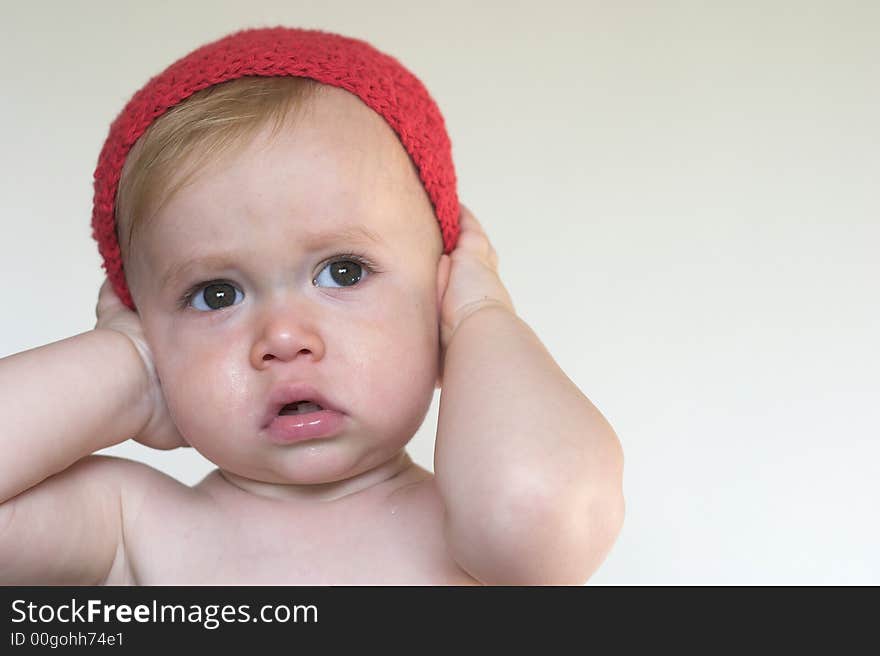 Image of cute toddler holding his hands over his ears