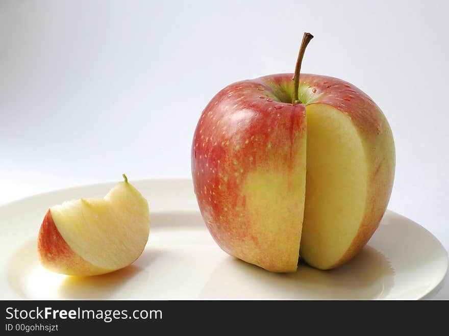 Juicy apple and its clove on a plate